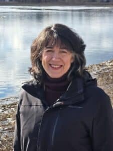 Image of Professor Conevery Valencius in front of an outdoor water scene.